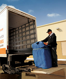 TTR worker loading copier onto truck for equipment shipping